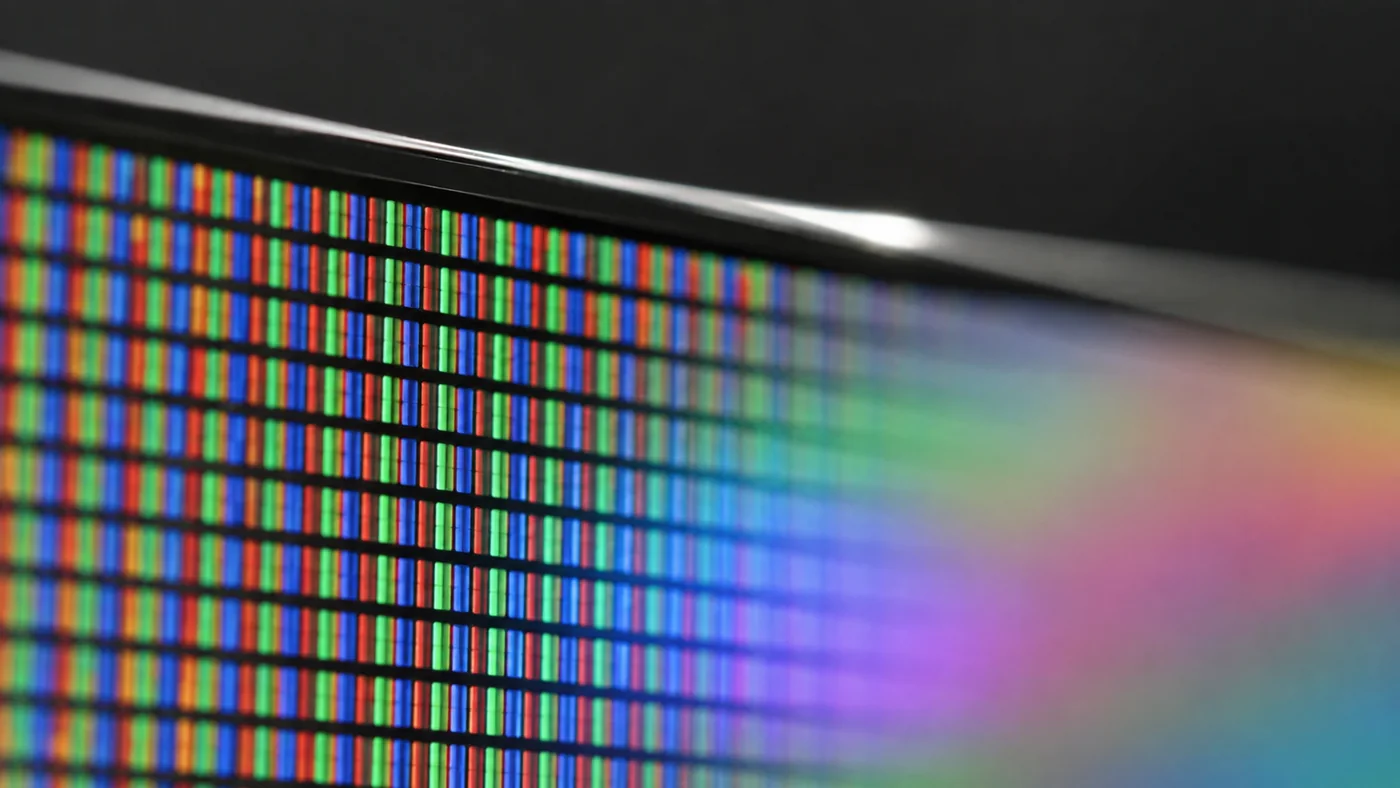 Extreme macro of a TFT LCD panel corner showing the red green and blue sub-pixel grid separated by black matrix lines