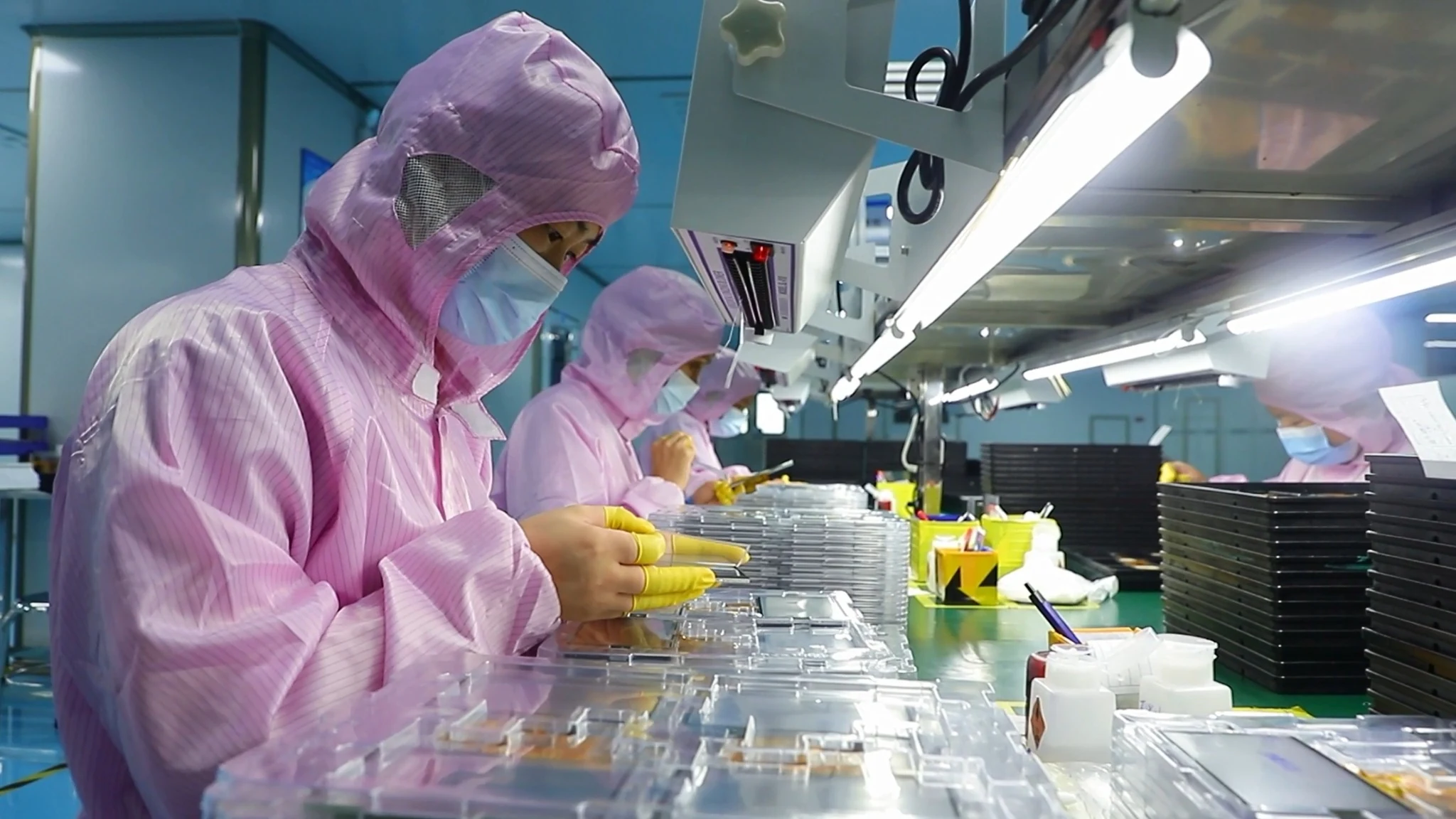 Operators inspecting TFT modules at the assembly line